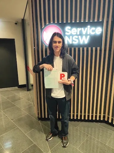 Driving School Liverpool Centre student holding a pass certificate at a Service NSW centre in the Macarthur region