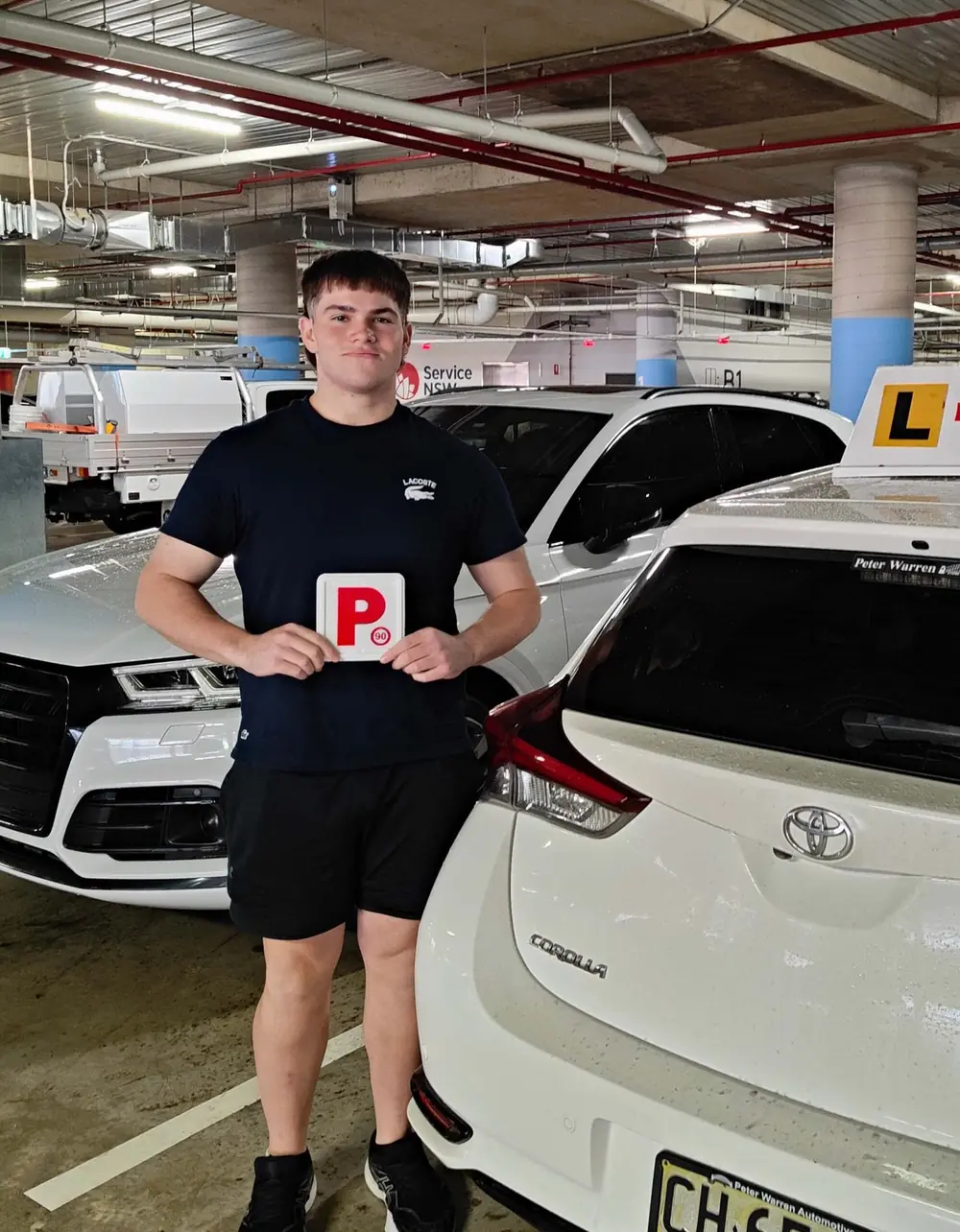 New P plate driver beside the learner car after passing the driving test in Liverpool